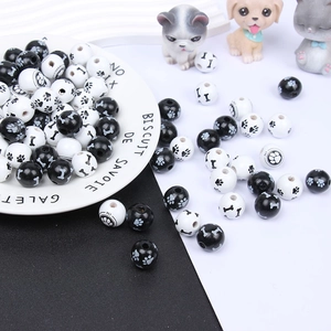 Detail view of black and white DIY wooden beads with printed pet paw and bone patterns