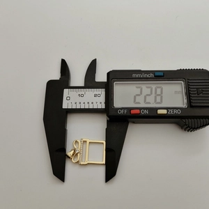 Detailed measurement of 22.8mm gold gift box pendant with zircon inlay using digital caliper