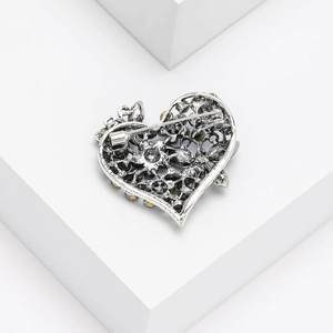 Detailed back view of vintage silver heart brooch showing pin clasp and carved hollow design