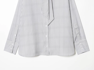 Detail of striped poplin shirt showing button placket and curved hem in white and black