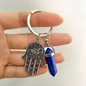 Macro view of Hamsa Hand pendant with evil eye and lapis blue crystal pillar keychain