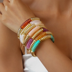 Détail macro de bracelets superposés en acrylique et métal avec texture filetée