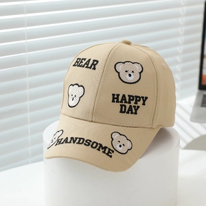 Close-up of khaki cotton baseball cap featuring bear embroidery and Happy Day text