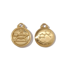 Detailed close-up of 18k gold Sagittarius pendants with archer icon and constellation map