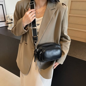 Fashionable black pebbled leather crossbody bag with multiple zippers and wide strap