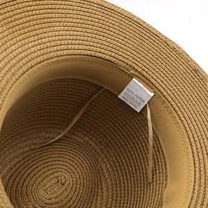 Detail view of woven 100% paper straw hat interior with sweatband and windproof strap