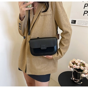 Detail showing matte and smooth black faux leather contrast on a stylish shoulder bag