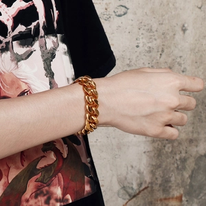 Men's heavy gold-tone stainless steel Cuban chain bracelet shown on wrist in side profile