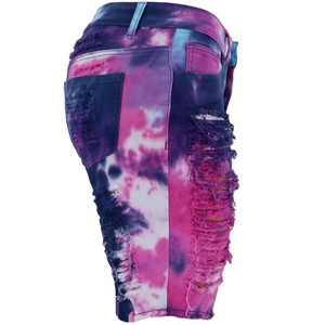 Detail view of purple tie-dye denim shorts featuring distressed ripped holes and side seam