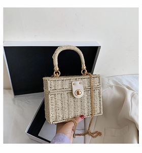 Detail der beigen geflochtenen Box-Tasche mit Goldkette und Metall-Drehverschluss
