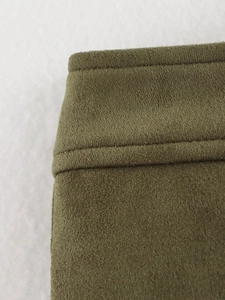 Detail shot of olive green faux suede fabric with precise double stitching and soft texture