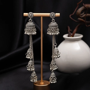 Detailed shot of vintage silver bohemian bell earrings with intricate floral carvings