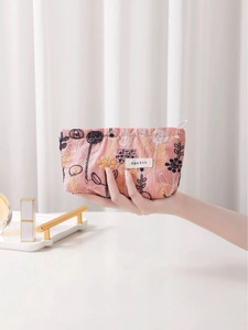 Pink floral embroidery makeup bag with zipper closure and white label detail