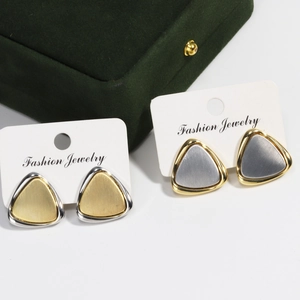 Macro shot of geometric triangle earrings with brushed metal finish and two-tone contrast