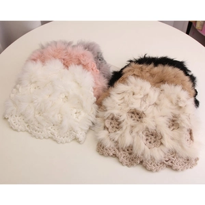 Top view of multicolored hand-knit crochet beanies with fluffy fur pom-pom detail