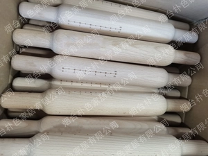 Close-up of solid wood rolling pins with laser-engraved cm and inch measurement scales