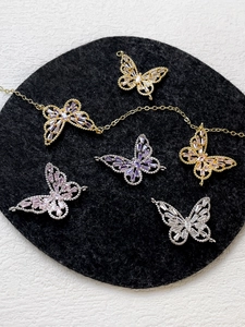 Detailed view of 14k gold-plated butterfly charms with inlaid colorful zircon stones