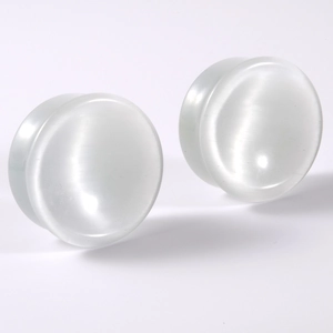 Detailed view of natural white cat eye stone ear plugs with glossy convex finish