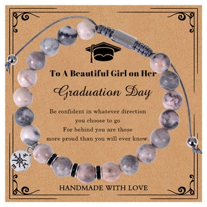 Detail of pink zebra stone graduation bracelet with compass charm and gift card