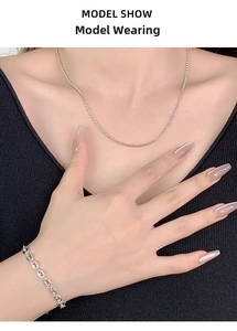 Close-up of S925 sterling silver pig nose link bracelet and beaded chain on a model