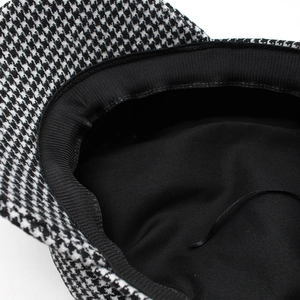 Détail de la casquette gavroche pied-de-poule avec doublure noire et cordon réglable