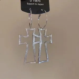Silver hollow cross hoop earrings with textured finish in a gothic punk fashion style