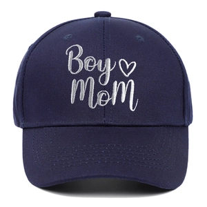 Detailed close-up of Boy Mom white embroidery and heart on navy cotton baseball cap