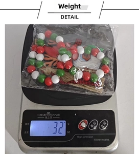 Close-up of a Christmas wooden bead ornament with Santa pendant on a digital scale