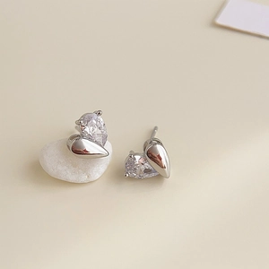 Detailed view of silver asymmetric pear-cut zircon and teardrop metal stud earrings