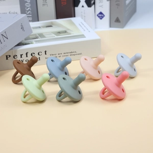 Detailed view of seven colorful food-grade silicone baby pacifiers with textured ring handles