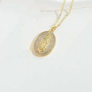 Close-up of gold plated Virgin Mary pendant with sparkling pavé crystals on O-chain