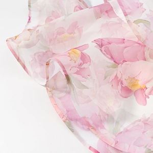 Detail view of pink floral print on soft mesh fabric showing lightweight chiffon texture