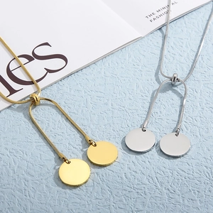 Minimalist gold and silver snake chain necklaces with round pendants on blue background