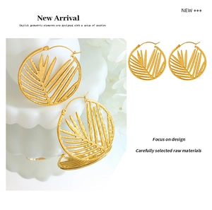 Detail of 18k gold hollow bamboo leaf earrings with intricate plant texture design