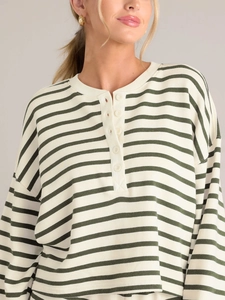 Close-up of green striped long-sleeve top with white buttons and Henley neckline