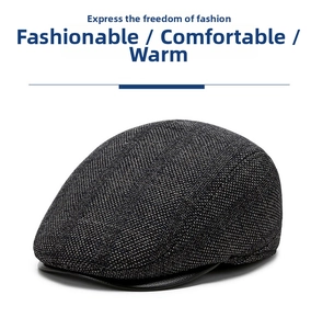 Detail of grey tweed flat cap featuring a black leather brim and vintage texture