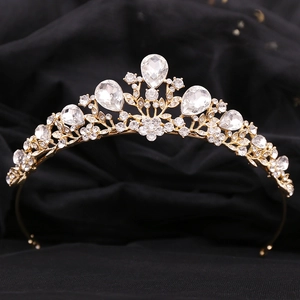 Close-up of golden bridal tiara with intricate leaf design and sparkling waterdrop crystals