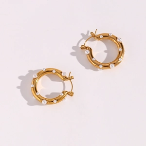 Detail of 18K gold-plated hoop earrings with small white pearls on a white background