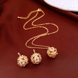 Detailed close-up of vintage gold jewelry set with floral patterns and red rubies