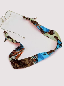 Close-up of retro floral silk ribbon glasses chain with elegant gold metal buckles