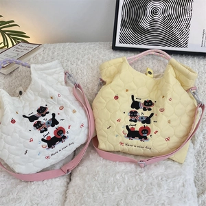 Detailed quilted heart texture with black cat embroidery on white and yellow tote bags