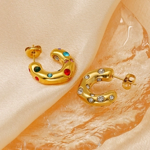 Macro detail of 18K gold plated C-shaped hoop earrings with colorful zircon inlay