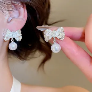 Boucles d'oreilles nœud argentées avec perles blanches et diamants pour femmes