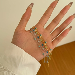Close-up of gold and silver Mobius bracelets with colorful opal stones in hand