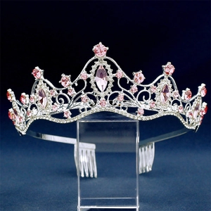 Close-up of silver bridal crown featuring pink crystal rhinestones on an acrylic stand
