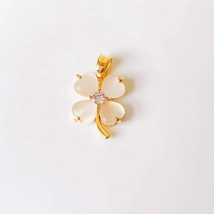 Detail of clover pendant with pink cat eye stone petals and zircon center in gold