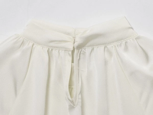 Detailed close-up of white satin shirt neckline featuring button and slit design