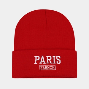 Detail of red knit beanie with white embroidered Paris and French text design