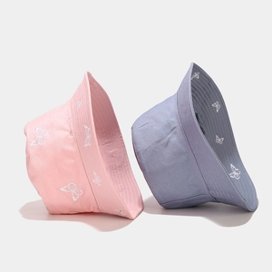 Close-up of butterfly embroidery details on pink and blue cotton bucket hats