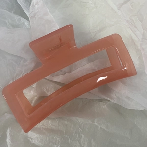 Close-up of a 13cm oversized rectangle jelly hair claw clip in soft peachy orange color